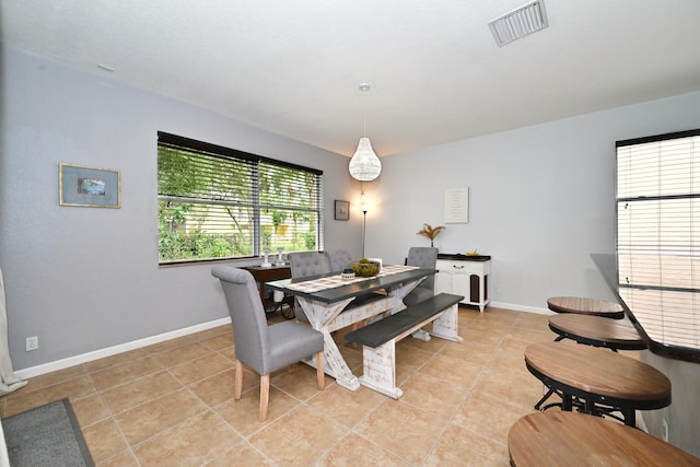 tiled dining space featuring a healthy amount of sunlight