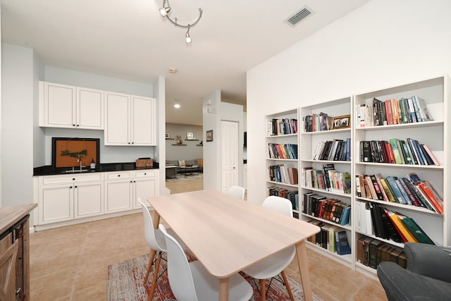 dining room featuring sink, built in desk, and light tile patterned floors