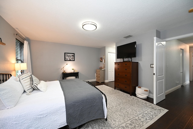 bedroom featuring dark wood-type flooring and a textured ceiling