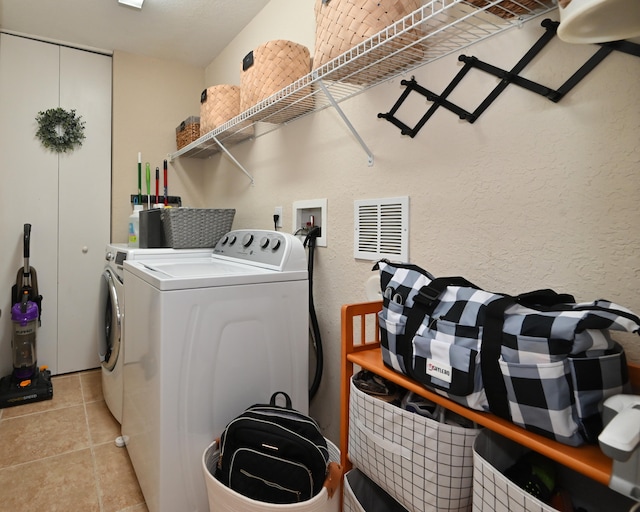 washroom featuring light tile patterned floors and washer and clothes dryer