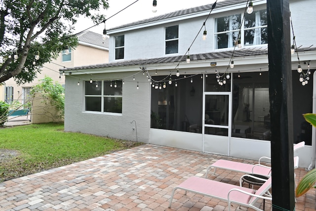 back of property featuring a sunroom and a patio area