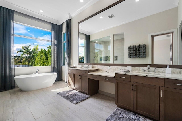 bathroom featuring shower with separate bathtub, vanity, ornamental molding, and a wealth of natural light