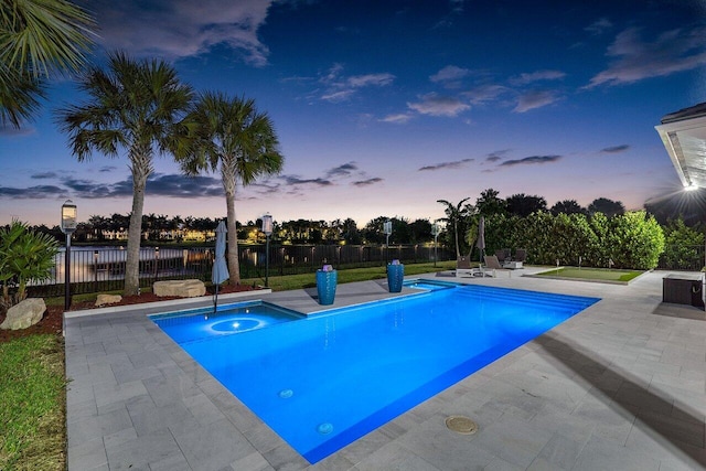 pool at dusk with a patio area