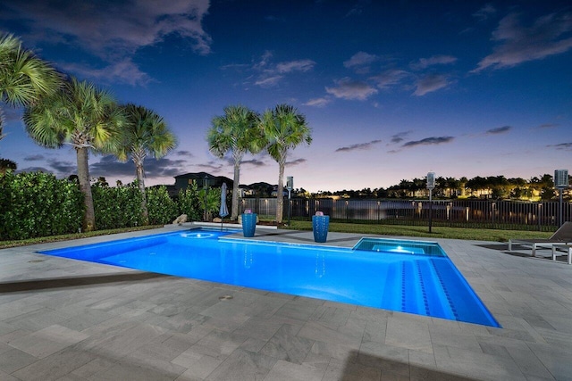 pool at dusk with a patio area