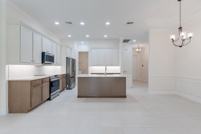 kitchen featuring white cabinets, pendant lighting, tasteful backsplash, a kitchen island with sink, and stainless steel appliances