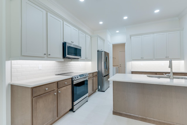 kitchen featuring sink, white cabinetry, backsplash, appliances with stainless steel finishes, and ornamental molding