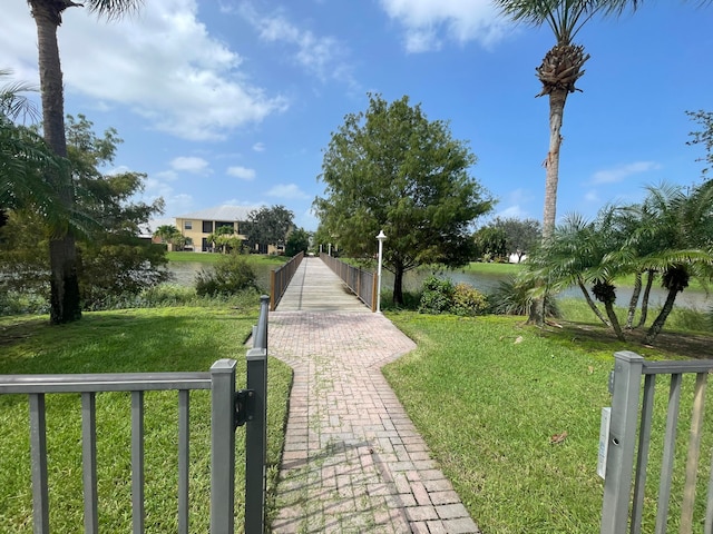 surrounding community featuring a lawn and a water view