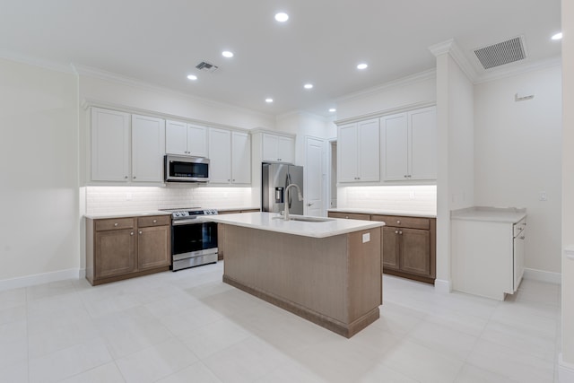 kitchen featuring backsplash, appliances with stainless steel finishes, a kitchen island with sink, and crown molding