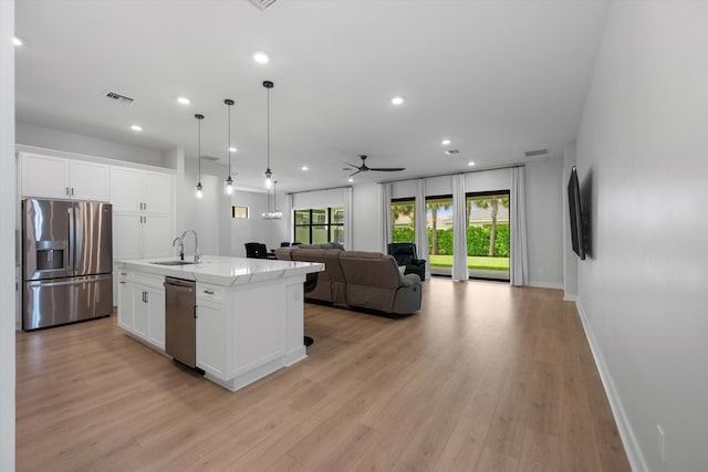 kitchen with a center island with sink, light wood-type flooring, white cabinetry, and stainless steel appliances