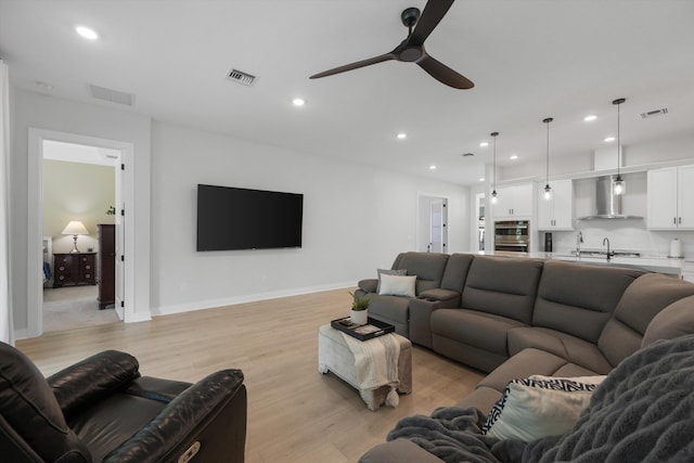 living room featuring ceiling fan and light hardwood / wood-style floors