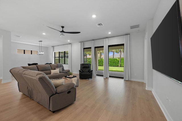 living room with a healthy amount of sunlight, ceiling fan, and light hardwood / wood-style flooring