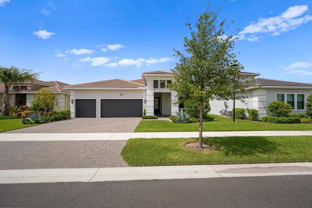 view of front of property with a garage and a front lawn