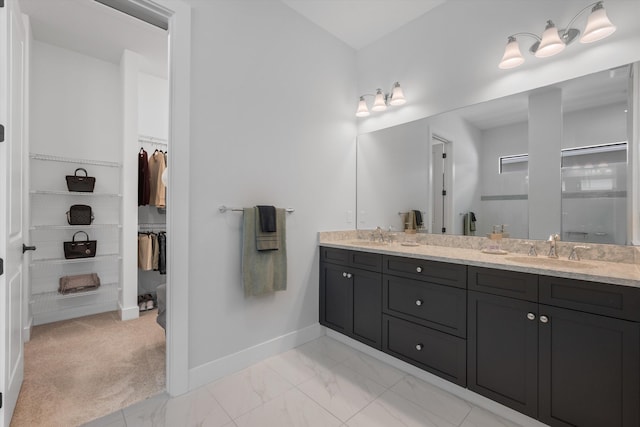 bathroom featuring a shower with shower door and vanity