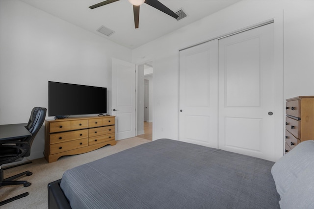 bedroom featuring ceiling fan, light colored carpet, and a closet