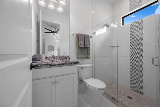 bathroom with ceiling fan, a shower with shower door, vanity, and toilet