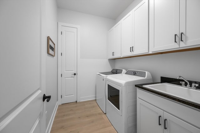 washroom featuring cabinets, light hardwood / wood-style flooring, sink, and washer and dryer