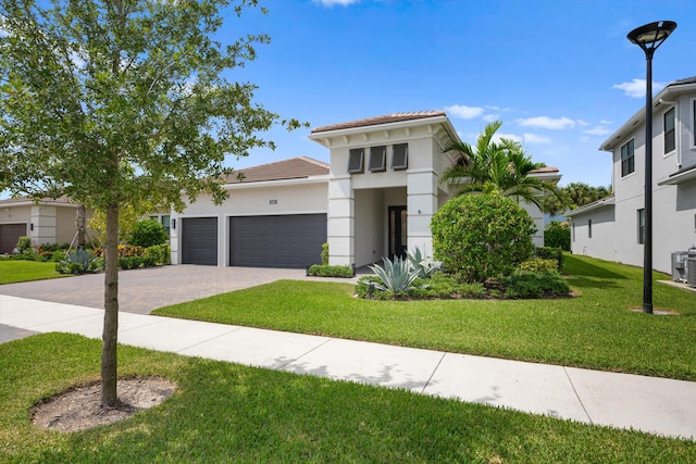 mediterranean / spanish-style home with a garage and a front lawn