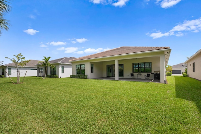 back of house featuring a lawn and a patio area