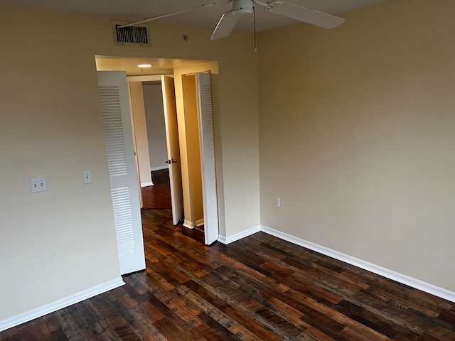 empty room featuring ceiling fan and dark hardwood / wood-style flooring