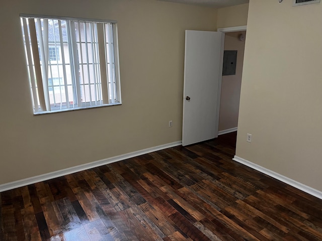 unfurnished room featuring dark hardwood / wood-style flooring and electric panel