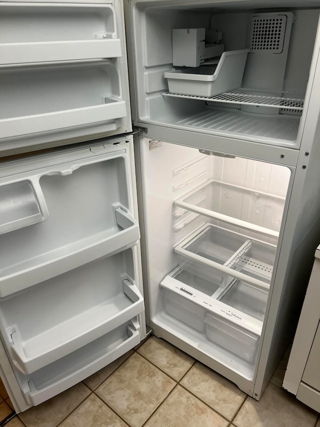 room details with refrigerator and light tile patterned floors