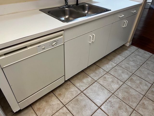 kitchen featuring light tile patterned flooring, dishwasher, and sink