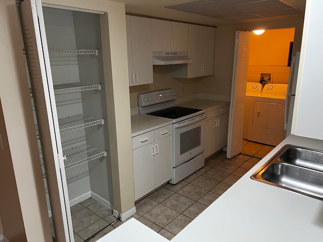 kitchen with white cabinetry, light tile patterned floors, white electric stove, sink, and washing machine and clothes dryer