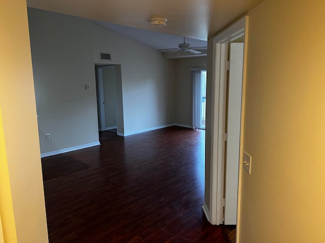 empty room featuring ceiling fan, lofted ceiling, and dark wood-type flooring