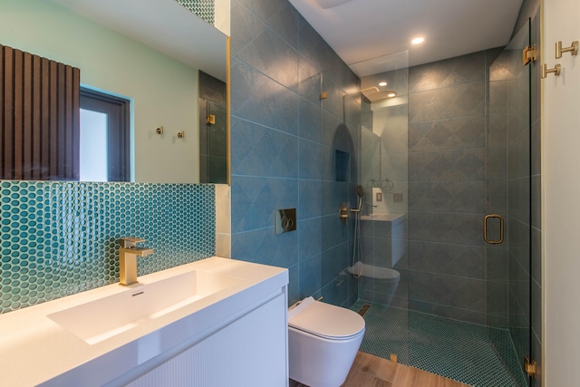 bathroom with vanity, an enclosed shower, tasteful backsplash, hardwood / wood-style flooring, and toilet