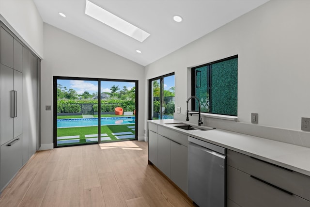 2435 Windsor Way Ct, Wellington, FL 33414 - kitchen with stainless steel dishwasher, a sink, a skylight, light countertops, and light wood finished floors