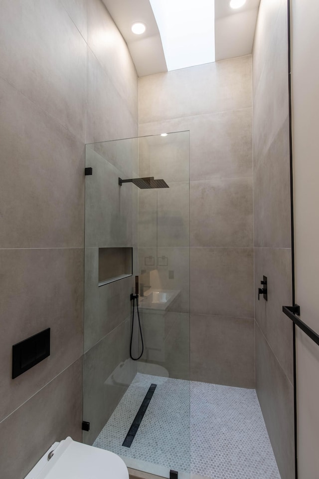 bathroom with tiled shower and toilet