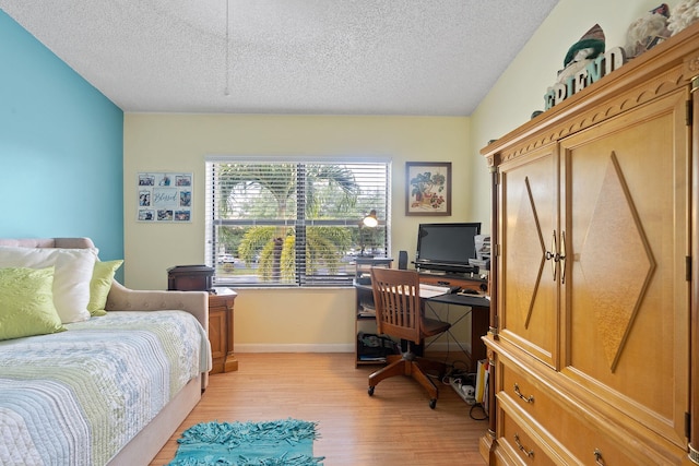 bedroom featuring a textured ceiling and light wood-type flooring