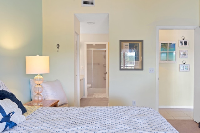 bedroom featuring light tile patterned flooring and ensuite bath