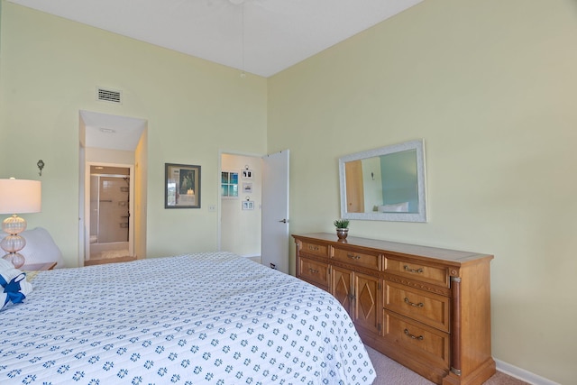 bedroom with a towering ceiling, light colored carpet, and connected bathroom