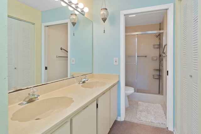 bathroom with vanity, a shower with shower door, and toilet