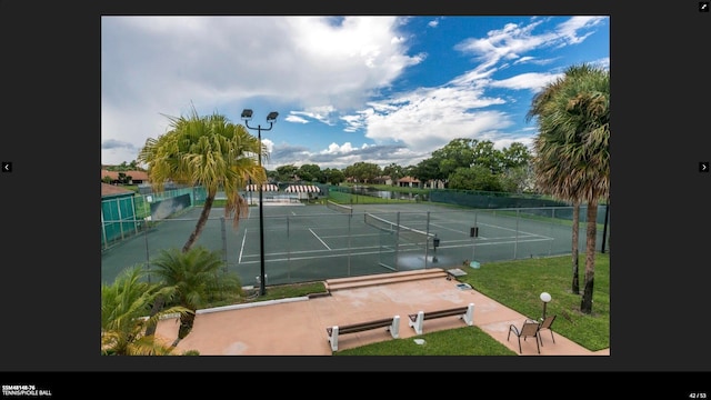 view of sport court featuring a lawn