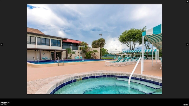 view of swimming pool featuring a community hot tub