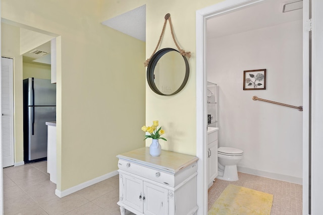 bathroom with toilet and tile patterned flooring