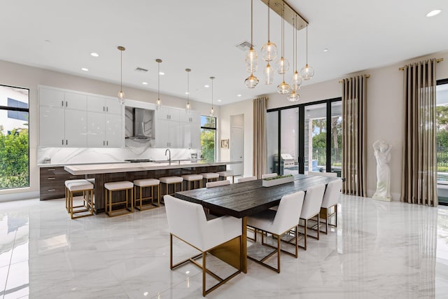 dining area featuring sink, a wealth of natural light, and an inviting chandelier