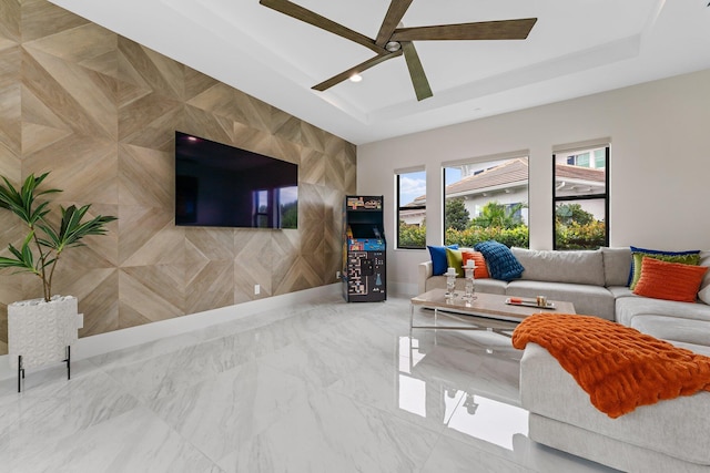 living room featuring a tray ceiling and ceiling fan