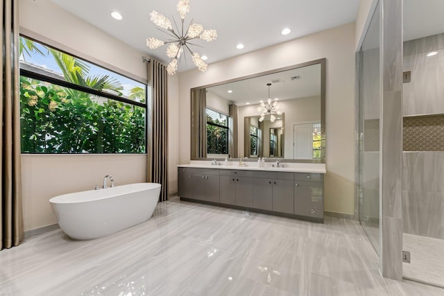 bathroom with vanity, a chandelier, and separate shower and tub