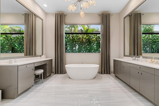 bathroom featuring vanity, a chandelier, and a washtub