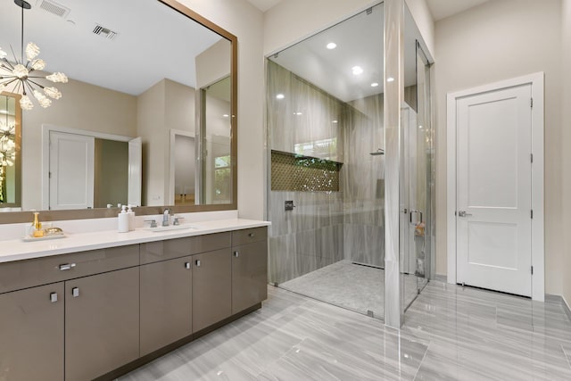 bathroom with vanity, a chandelier, and a tile shower