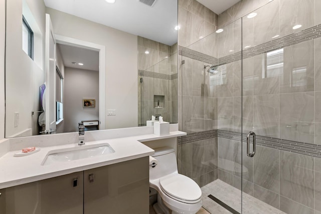 bathroom with vanity, an enclosed shower, and toilet