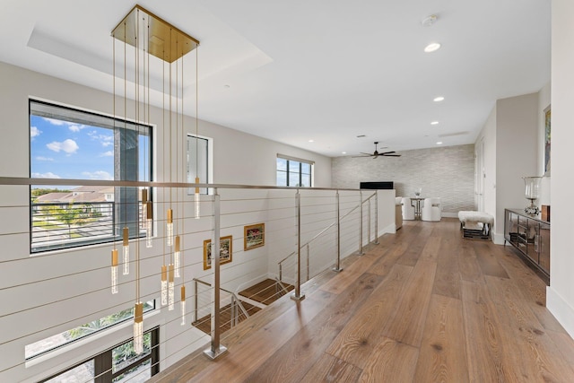 hallway with tile walls and light hardwood / wood-style flooring