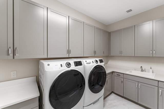 laundry area with cabinets, sink, and separate washer and dryer