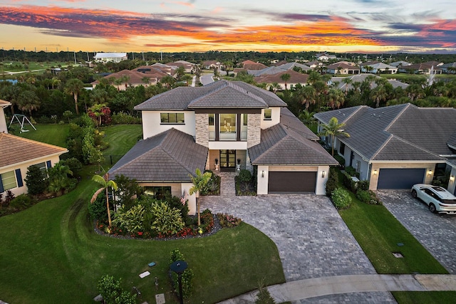 view of front of home with a yard and a garage