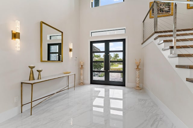 foyer entrance featuring french doors, a high ceiling, and plenty of natural light