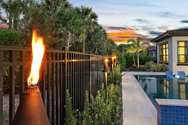 pool at dusk with a fire pit