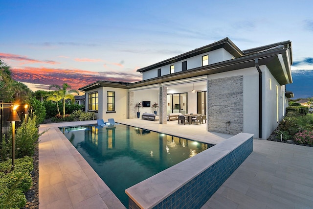 back house at dusk with a patio